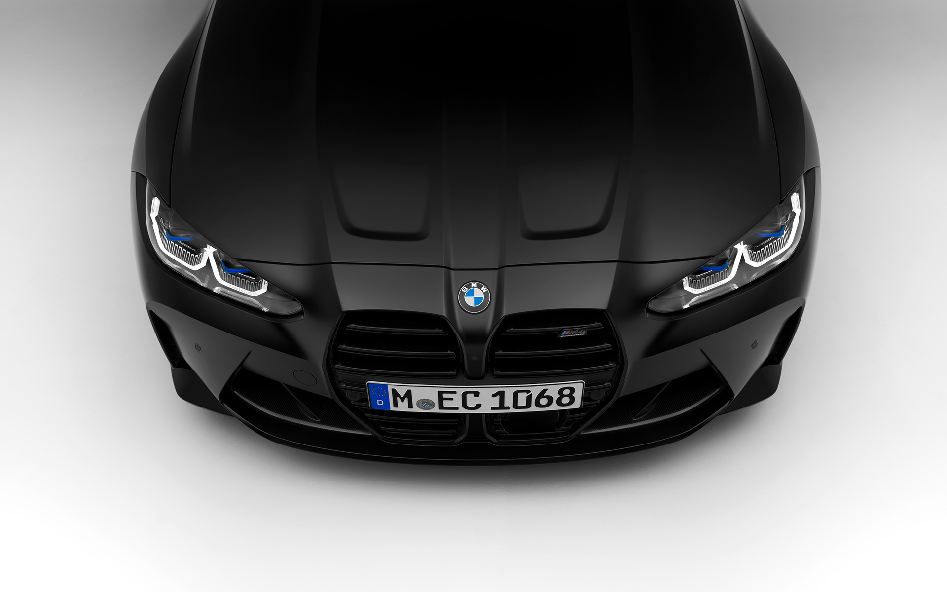 BMW M4 Competition Coupé G82 2021 BMW Individual Frozen Black metalik pogled sprijeda BMW M4 Competition Coupé G82 2021 BMW Individual Frozen Black metalik stojeći pogled sprijeda u presjeku odozgo