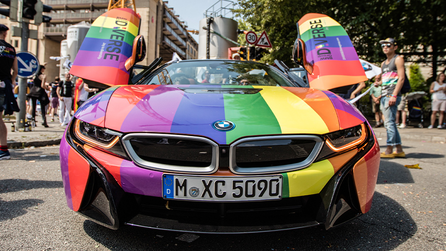Raznolikost Održivost BMW-a BMW Sustainability Diversity Pogled sprijeda BMW vozila u duginim bojama s otvorenim vratima u obliku galebovih krila