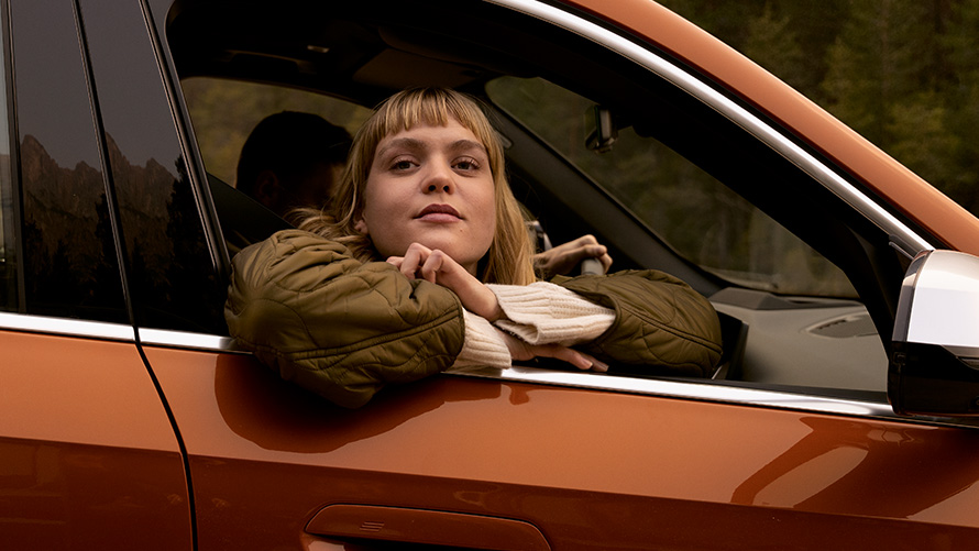 Žena se naginje kroz prozor automobila