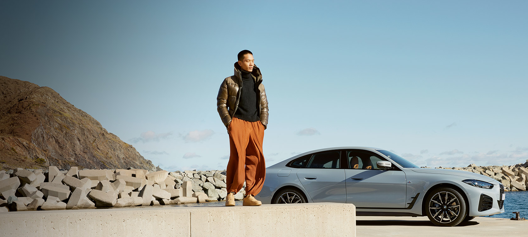 BMW Service Inclusive BMW Service Inclusive muškarac ispred BMW-a i4 na obali